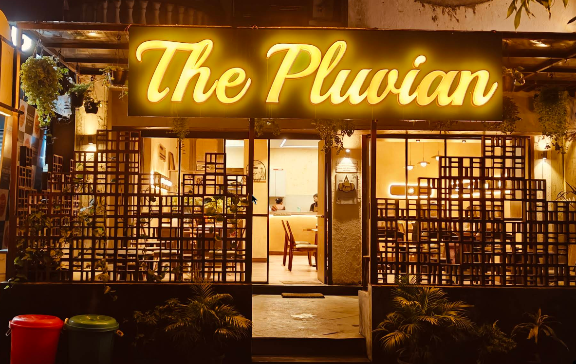 The Pluvian cafe exterior with warm golden signage